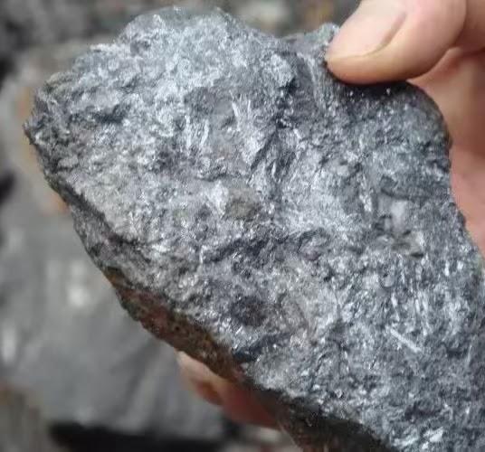 Amostra mineral escura de textura cristalina
